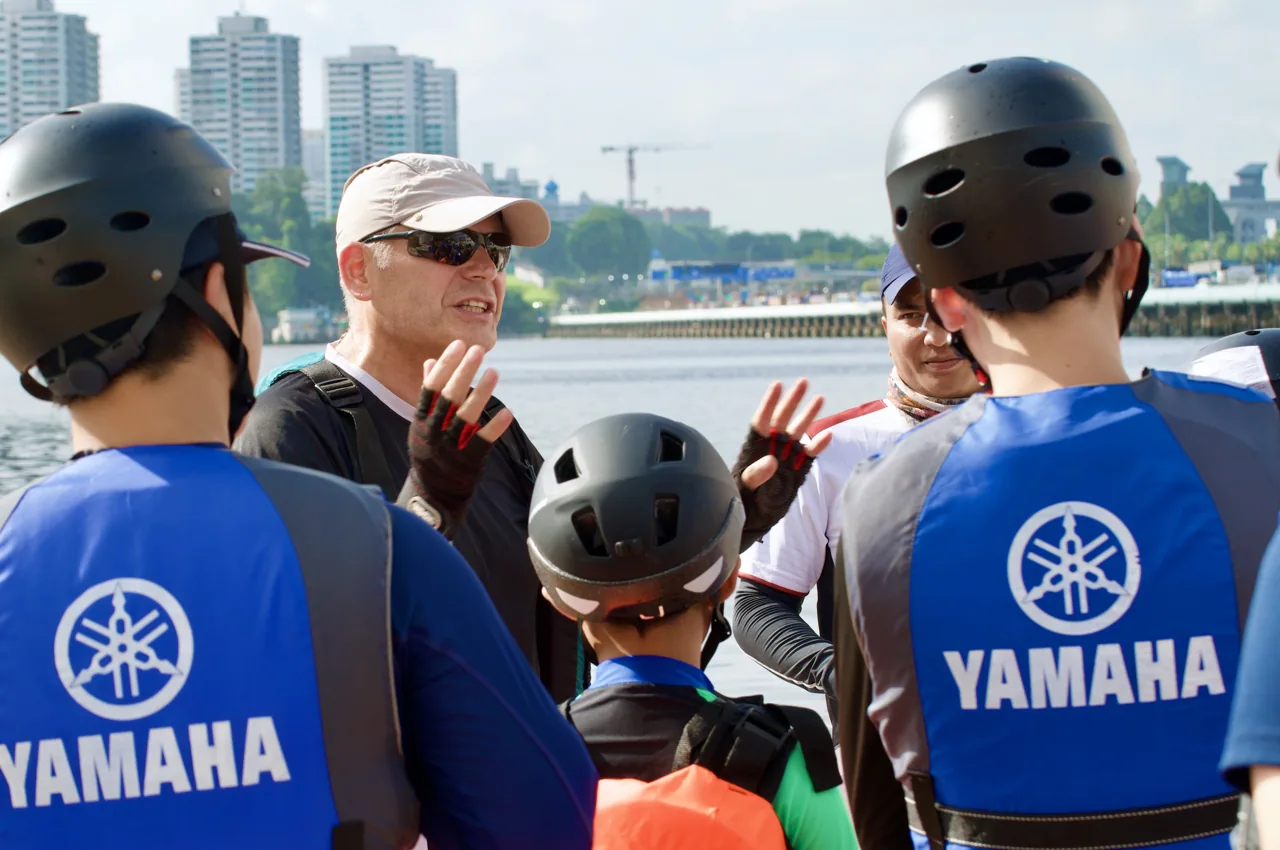A SeaQuest instructor briefing helmeted students wearing buoyancy aids